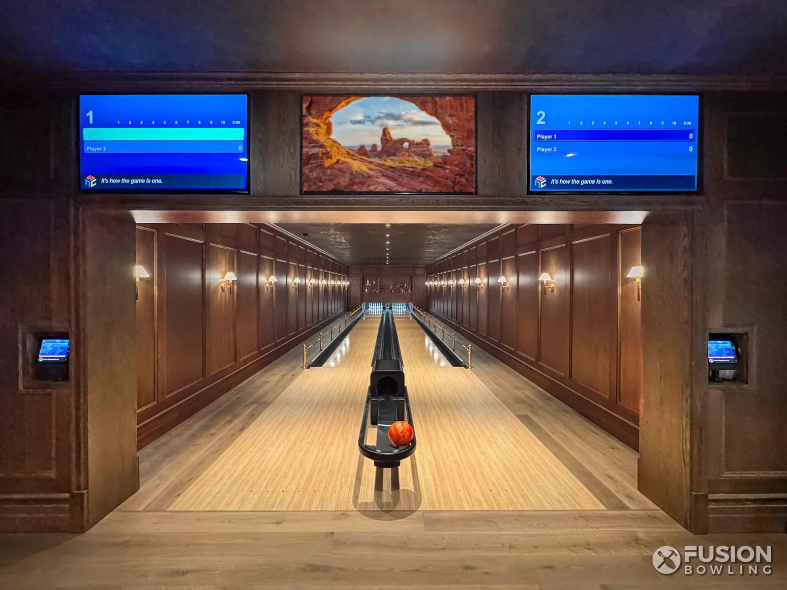 Two bowling lanes with dark wood paneling, brass rails and recessed scoring screens.